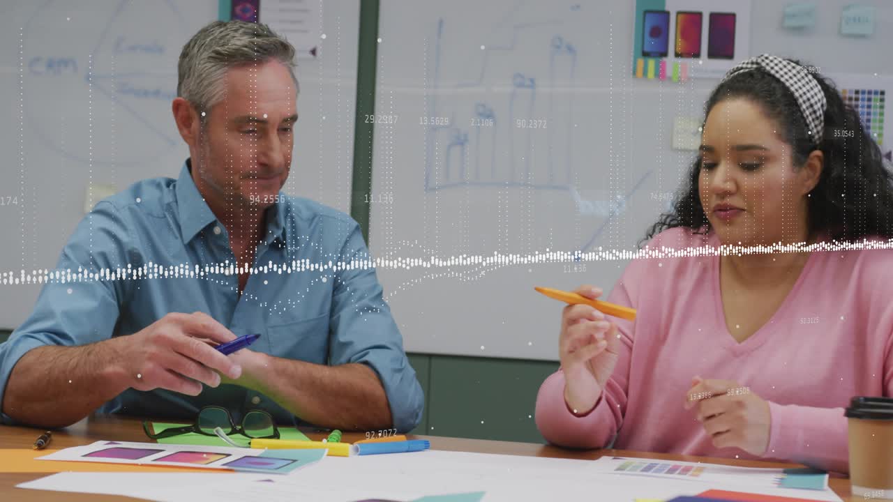 Design lead uncapping blue marker, marking while designer pointing orange swatch, agreeing on color