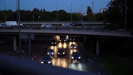 cars on highway in germany at night, headlights coming at camera, bridge across road with cars passing by