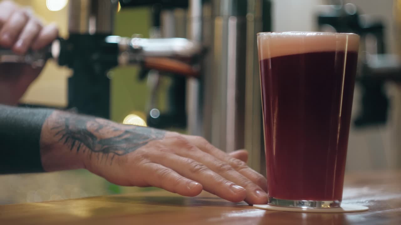 Barkeeper zapft ein Glas Craft Beer vom Zapfhahn in einer Bar