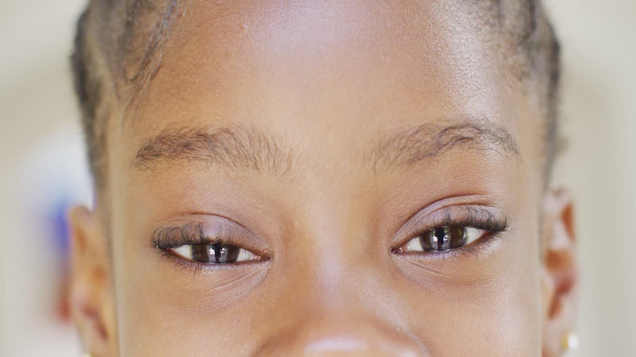 Close up portrait of eyes of happy african american girl opening and smiling, slow motion