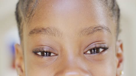 retrato de cerca de los ojos de una feliz chica afroamericana abriéndose y sonriendo, en cámara lenta