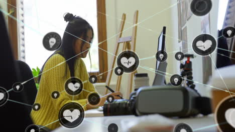 animación de la red de conexiones con íconos del corazón sobre mujer de negocios biracial en la oficina