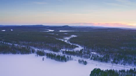 aerial – winter landscape with spacious fields, forests and lakes in northern europe