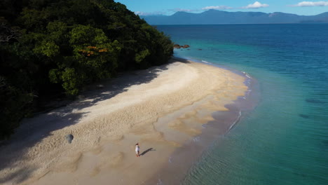 Reveladora-Toma-De-Drones-De-Una-Mujer-Caminando-En-El-Agua-En-La-Isla-Fitzroy,-Australia