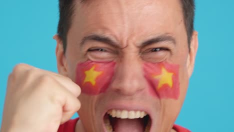 close up of a man supporting vietnamese team