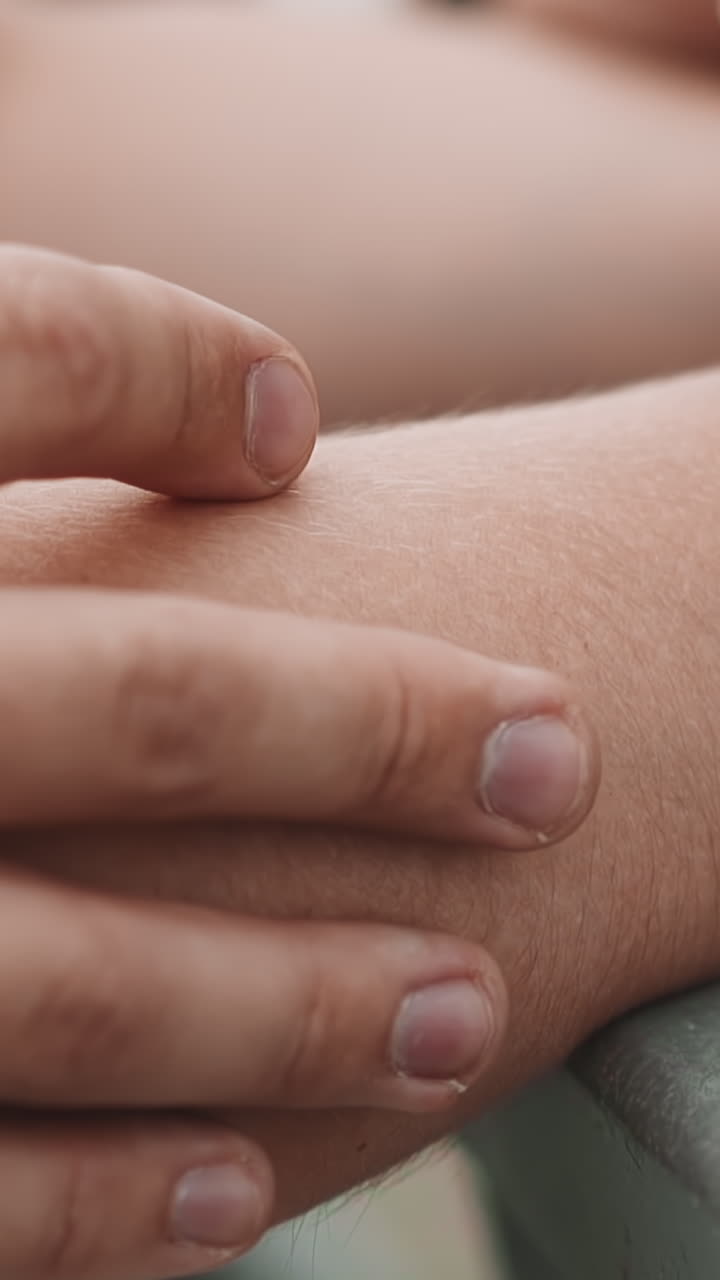 Careful guy strokes arm of bride holding bouquet at wedding ceremony closeup slow motion. Young man and woman at wedding. Family event celebration