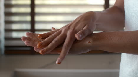 Woman applying salt scrub to her arm