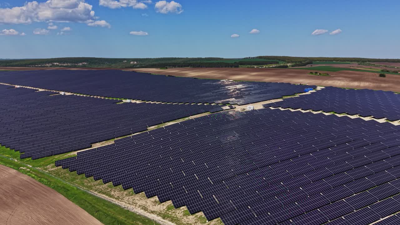 Solpaneler dækker et stort landområde i et solrigt landskab.
