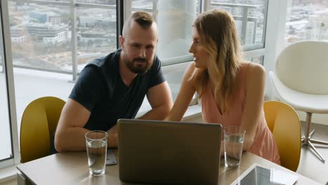couple using laptop in living room 4k