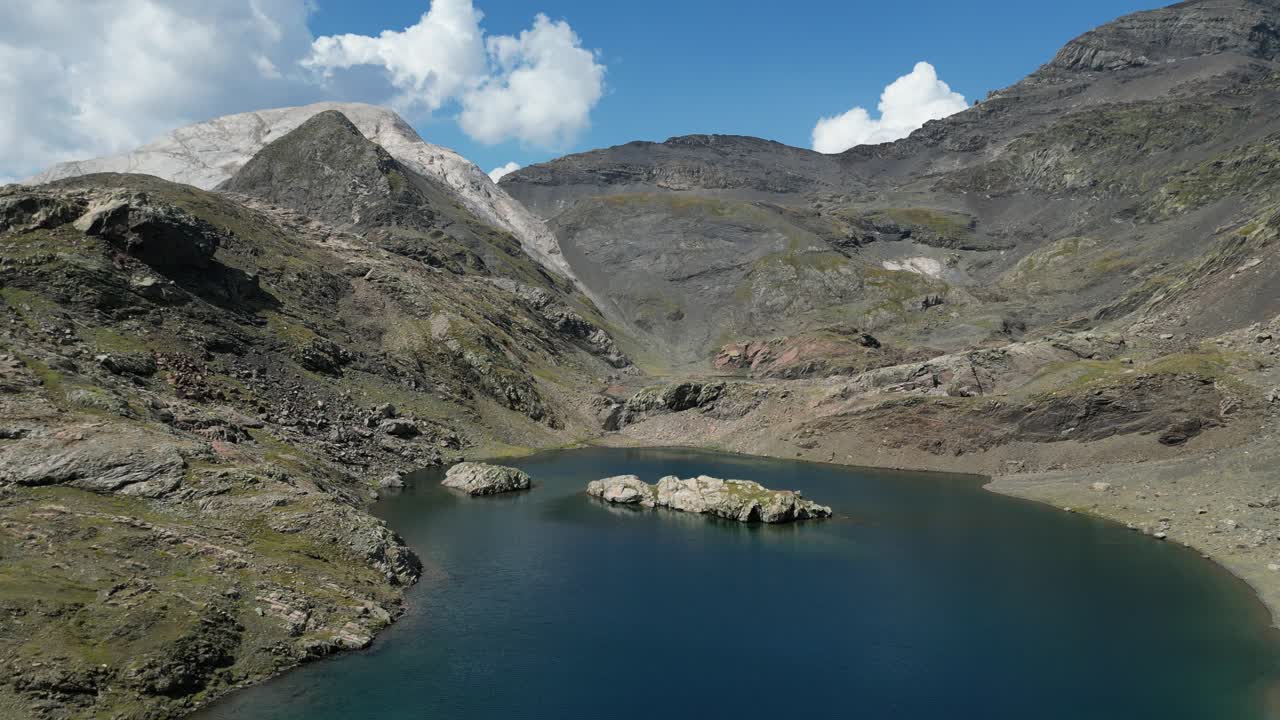 dronie aéreo de estanque azul cristalino en una cordillera escarpada