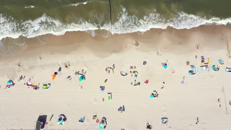 Strand-Mit-Bunten-Sonnenschirmen-Und-Menschen,-Die-Sich-An-Einem-Sommertag-Entspannen