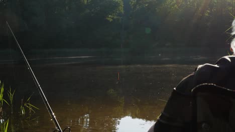 Pescador-Pescando-En-El-Lago-Mientras-Fuma-Con-Humo-Blanco-Saliendo-Del-Lado-Derecho-Del-Video