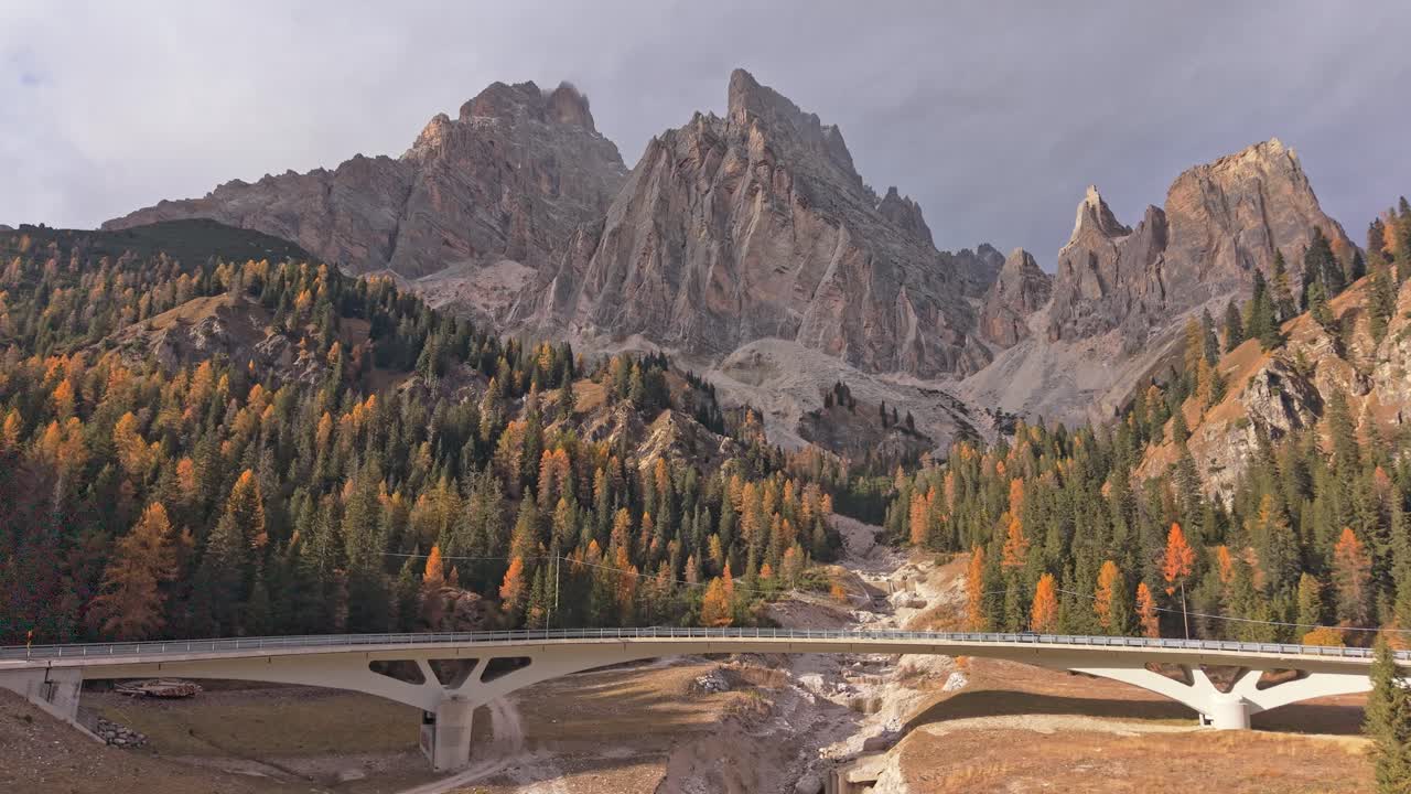 Droneoptagelse af naturskøn bro med Dolomitternes tinder om efteråret, Norditalien