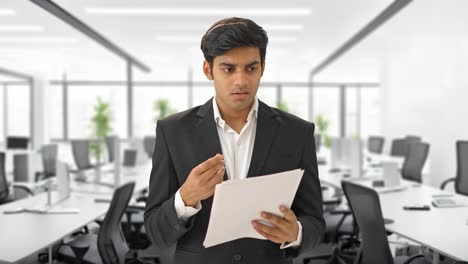 stressed and tensed indian manager reading contracts