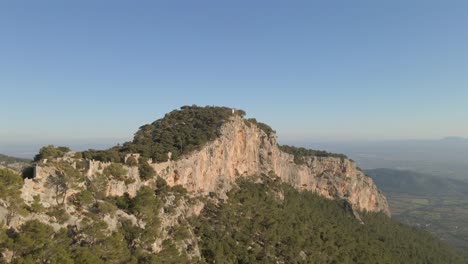 discover the breathtaking beauty of mallorca's tramontana mountains, featuring rugged cliffs, vast greenery, and a clear blue sky.