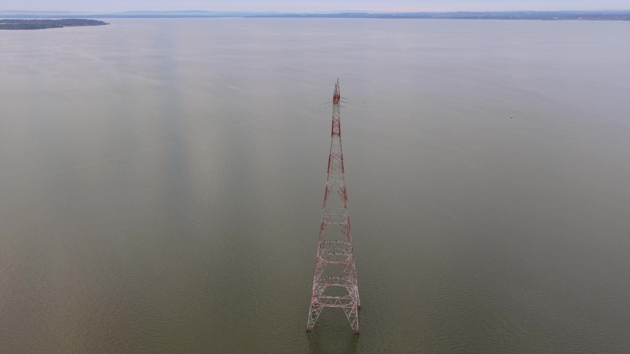 Uluslararası bir nehir üzerinden elektrik taşıyan iletim altyapısının drone görüntüsü.