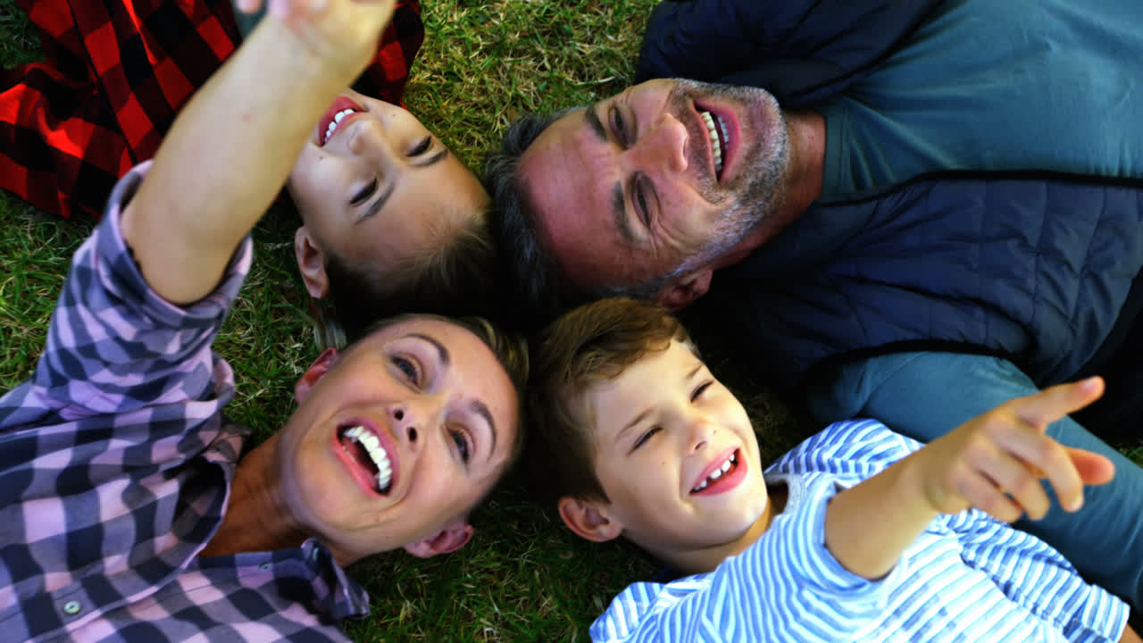 Família feliz deitada na grama