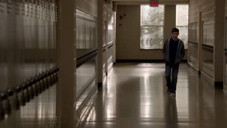 young man walking down a school hallway