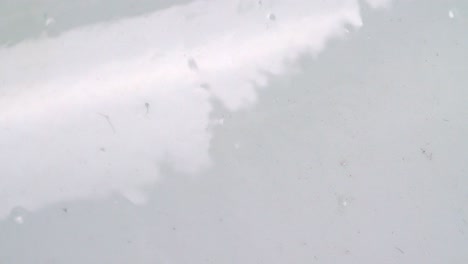 agua con burbujas que fluyen hacia abajo en una pared lisa y brillante