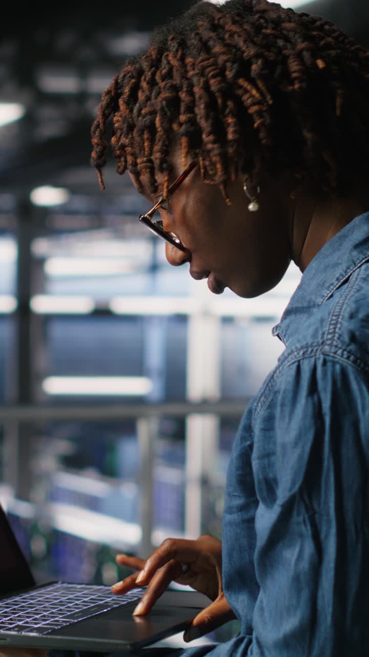 Vertical video Technician in data center stressed by critical error popup on laptop