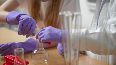 people studying chemistry in protection gloves and mask in school class.