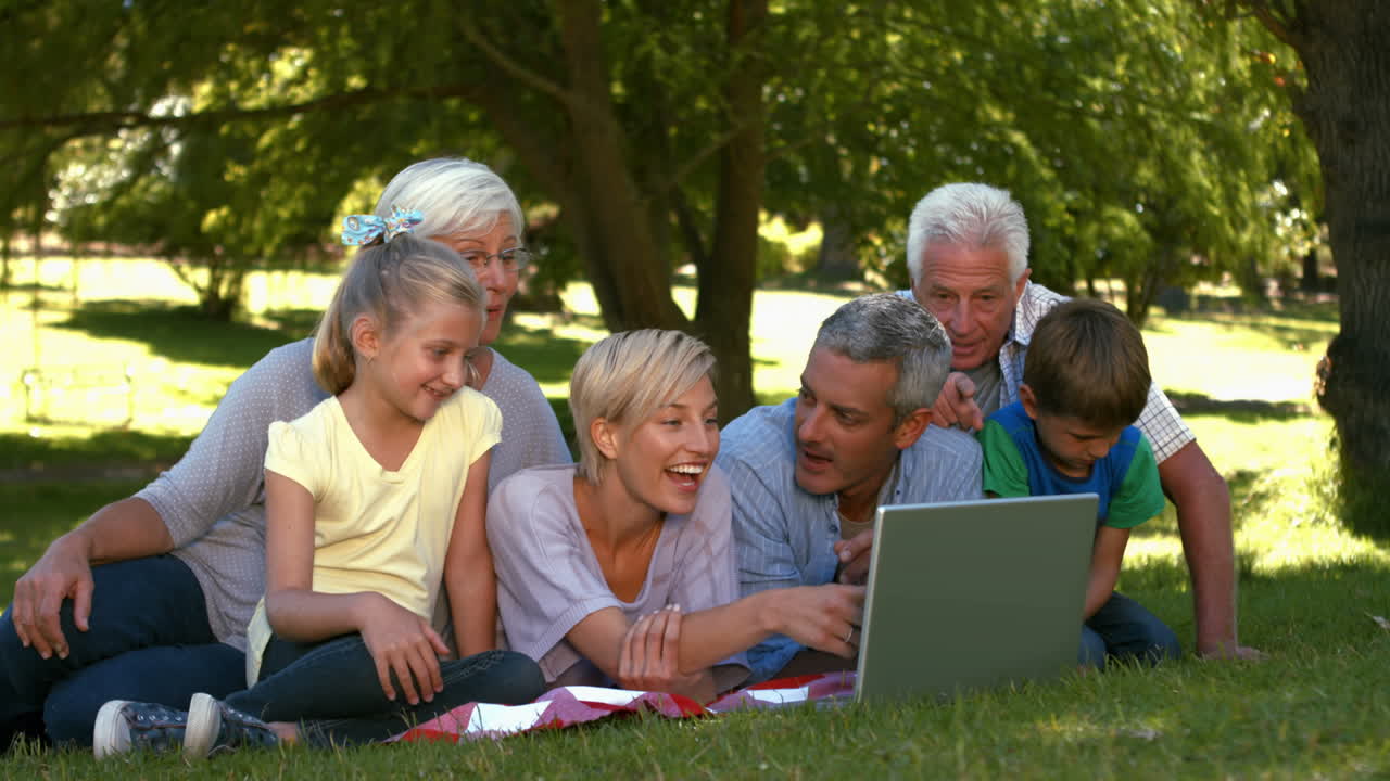 Happy family with laptop in park
