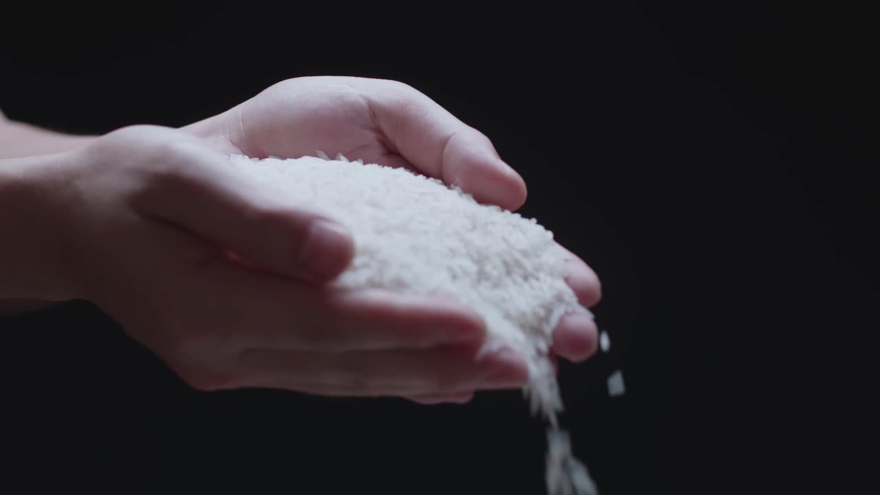 Handful Of Raw White Rice Grain Pouring From Hands In A Slow Motion