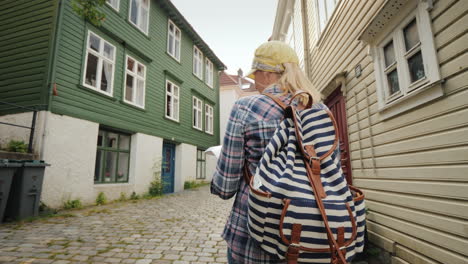 tourist mit einer karte in ihren händen, die durch die engen straßen von bergen in norwegen spazieren urlaub in s