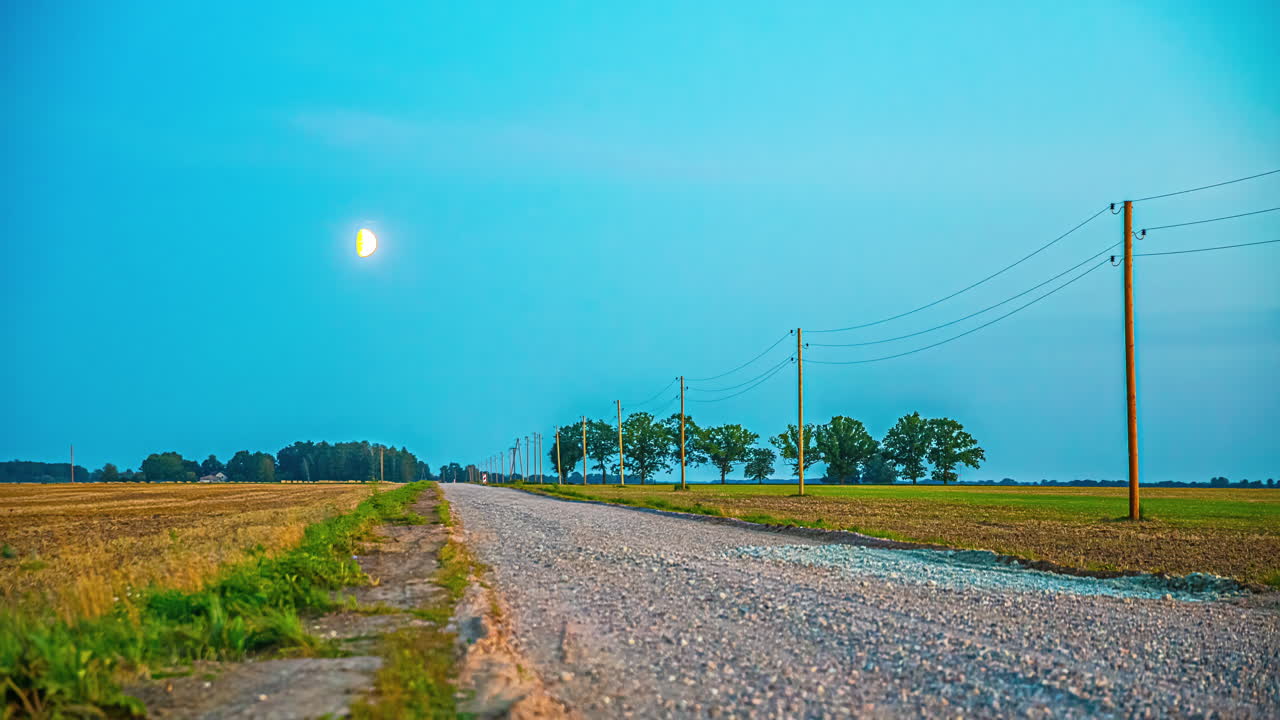 달이 시골 농장 위를 가로질러 하늘을 가로지르고 있습니다.