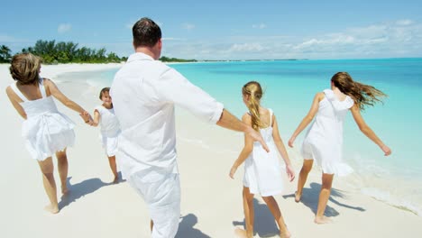caucasian parents and their female children enjoying beach