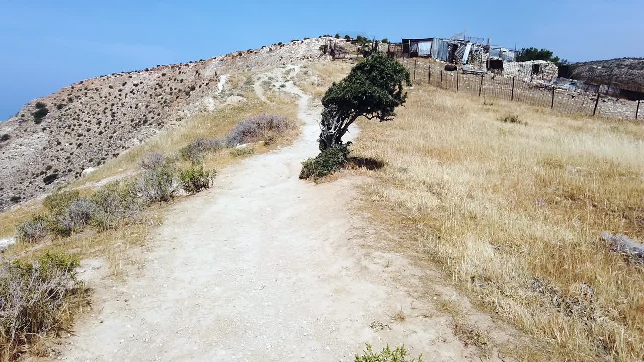 Scenic countryside path leading to the top of Pissouri White Cliffs in Cyprus, passing abandoned farmland and dry rural terrain. Perfect for travel, nature, and Mediterranean landscapes.