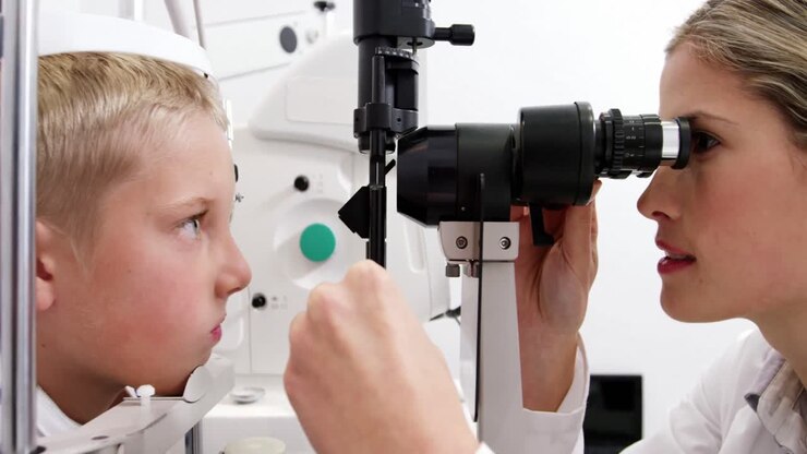 Optometrist examining patient on slit lamp