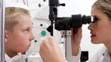 optometrista examinando al paciente con una lámpara de hendidura