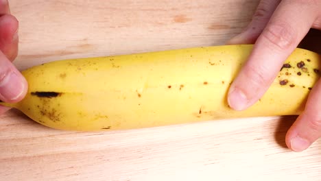 hands peeling a banana on a table