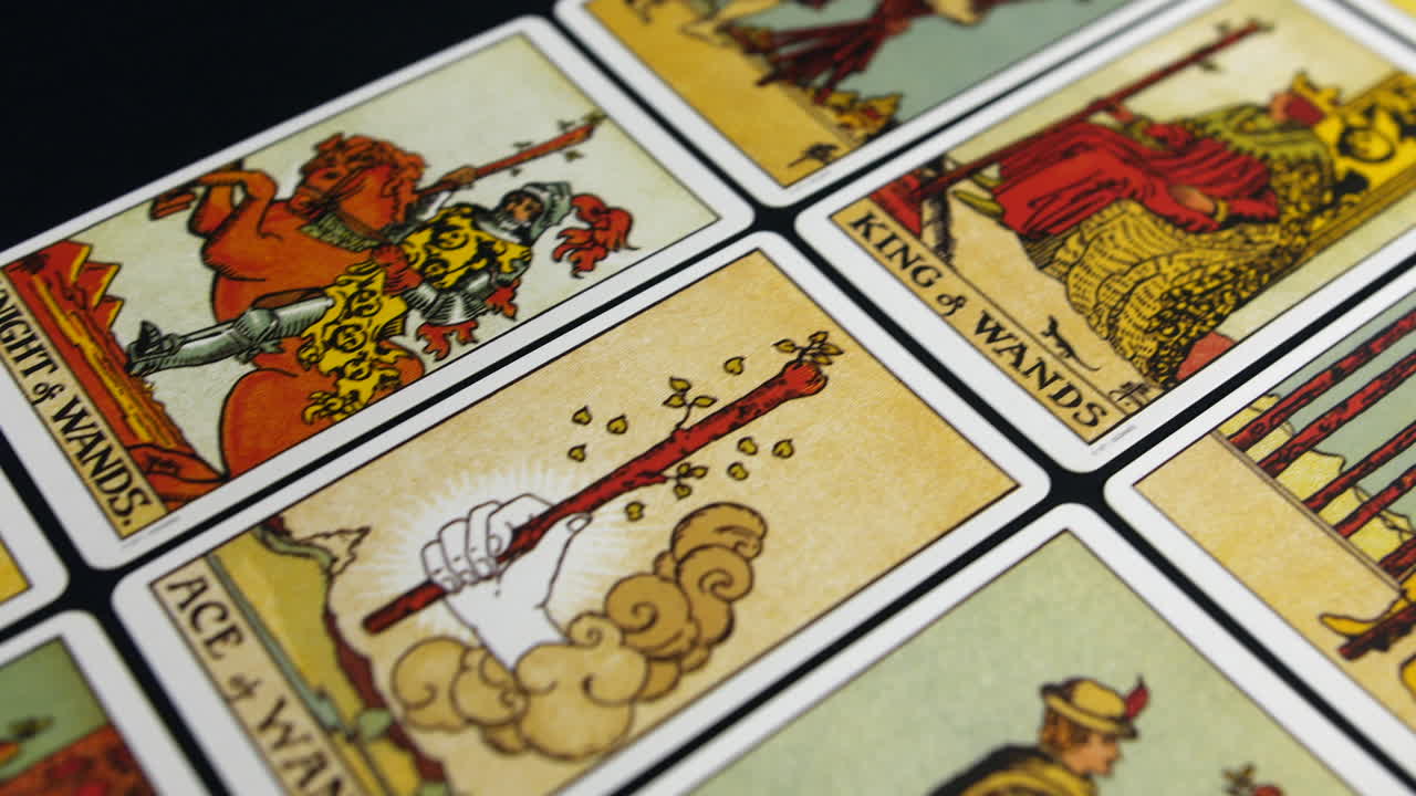 cartas del tarot del traje de varitas acostadas en una superficie plana, con una cámara rastreando a través de las ilustraciones detalladas. colores vibrantes e imágenes místicas llenan el marco
