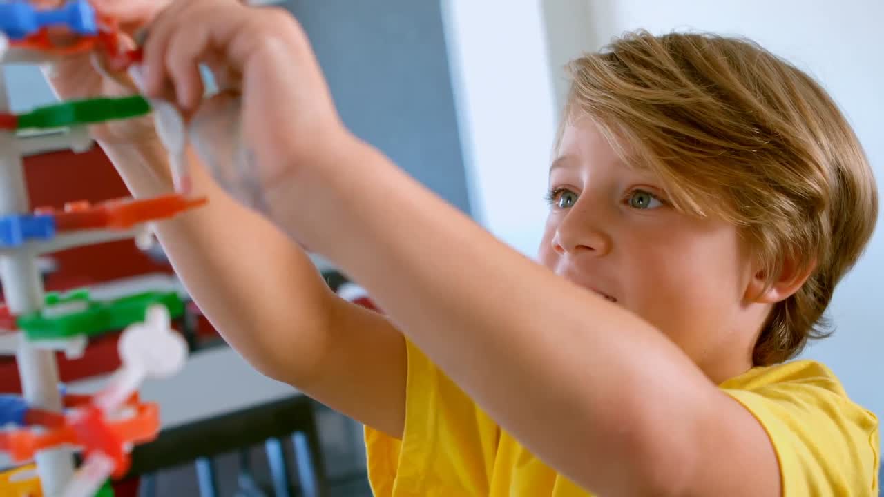 un escolar caucásico lindo estudiando el modelo de adn en el aula de la escuela 4k