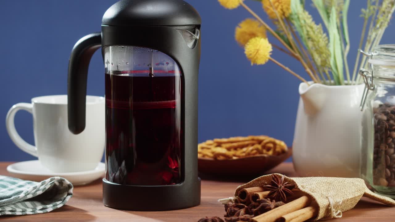 Brewing black tea in a teapot close-up. Drinking hot herbal drink on blue background