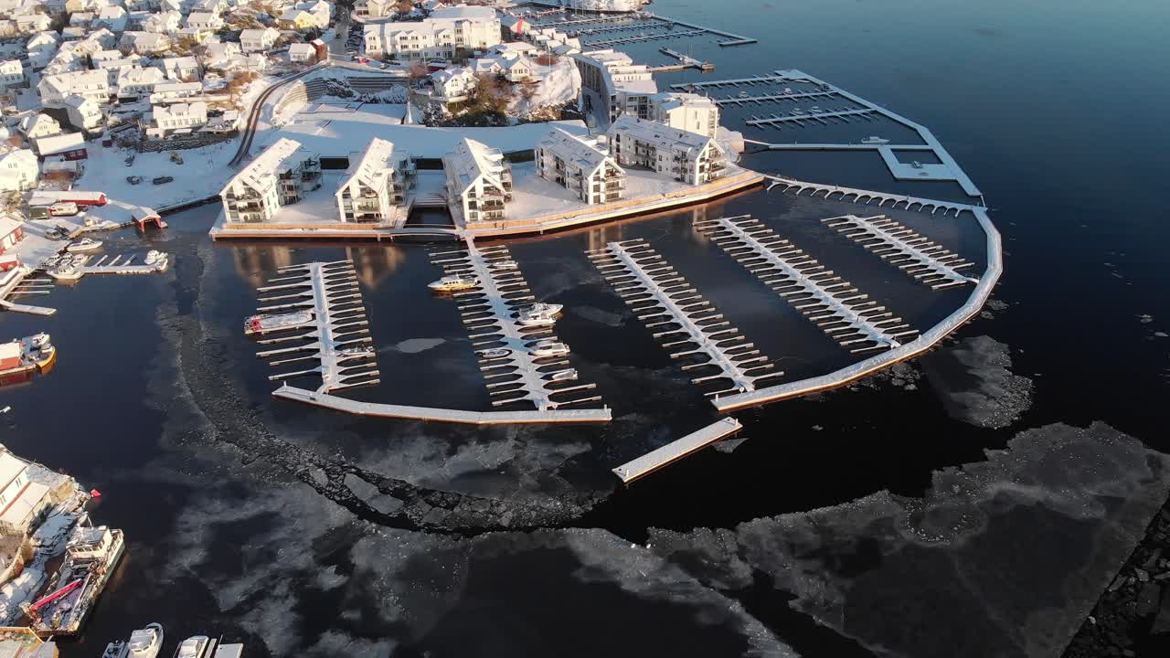 노르웨이 크라게로에 있는 빈 부두와 정박지가 있는 물에 떠 있는 금이 간 얼음