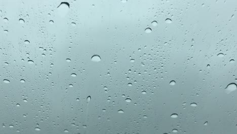 rain drops flowing on a driving car's windshield