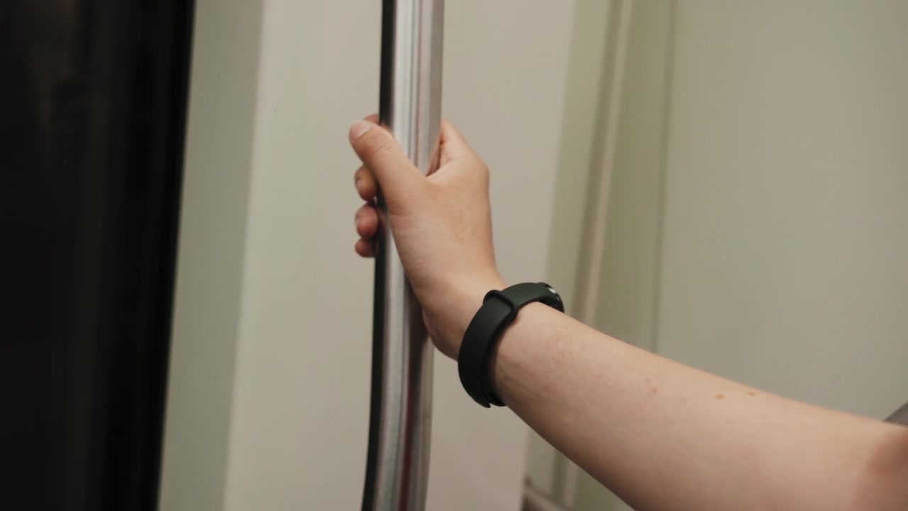 La mano di una donna si aggrappa al maniglione su un treno della metropolitana di Napoli