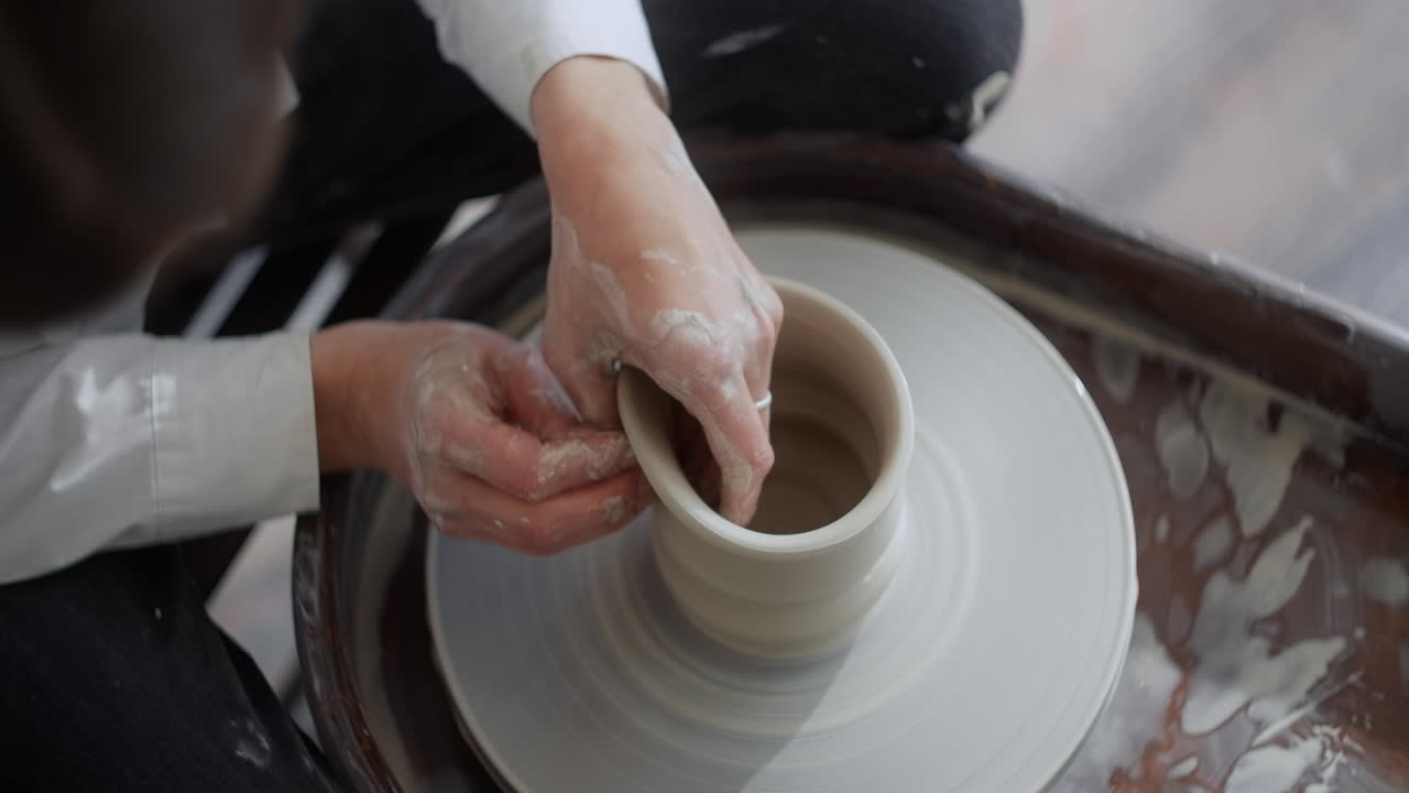 Woman making a ceramic piece on a pottery wheel