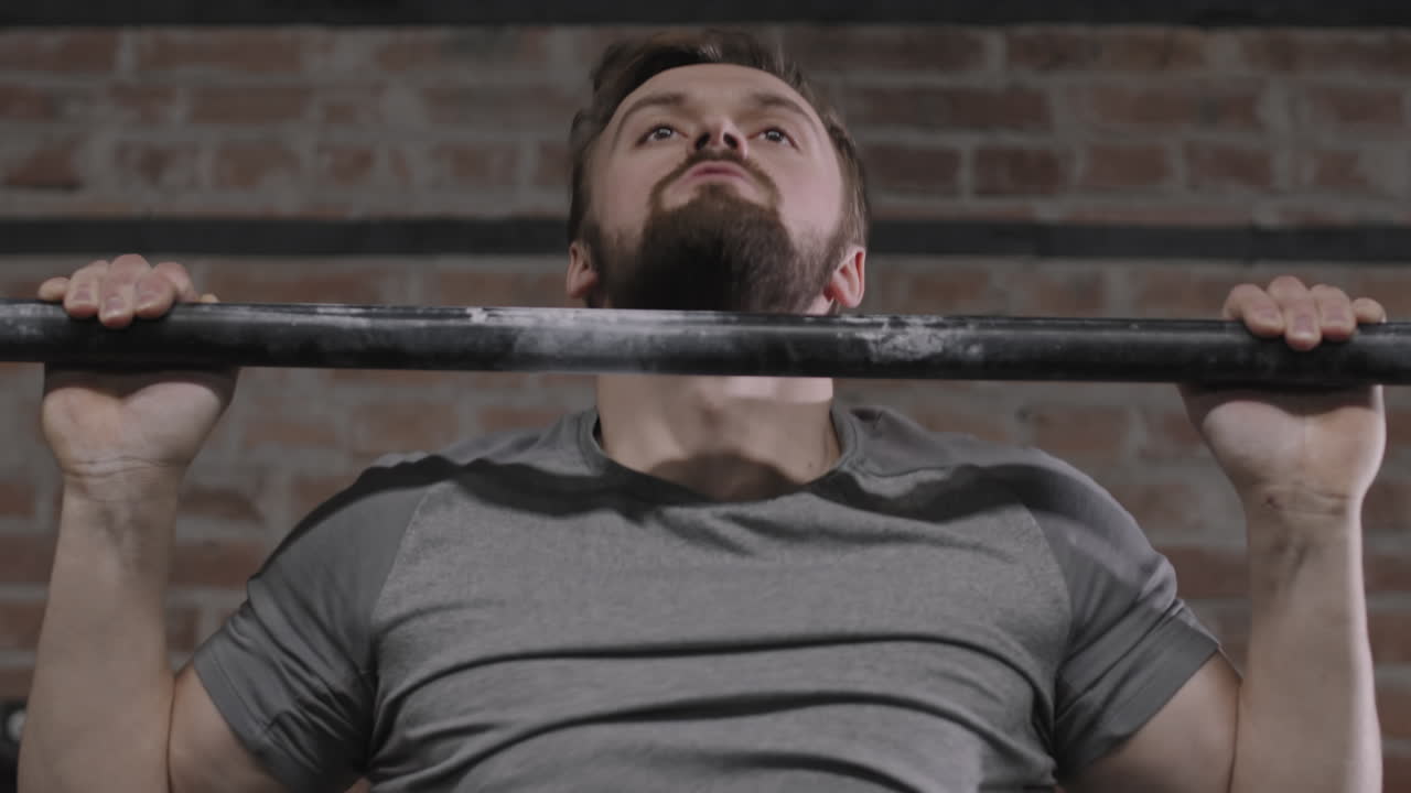 Sporty Man Pulling Up on Horizontal Bar