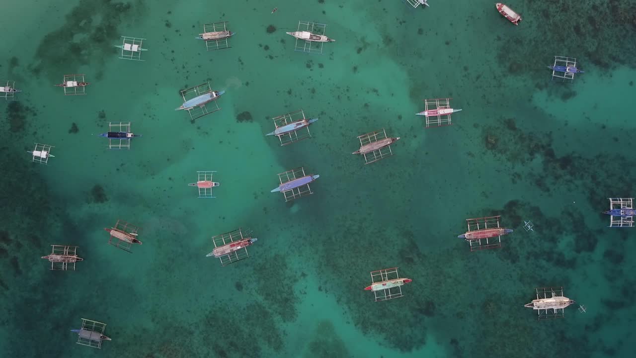 보라카이, 많은 보트가 크루즈색, 은 물에 정박하고, 산호가 보인다. 공중에서 천천히 내려오고 있다.