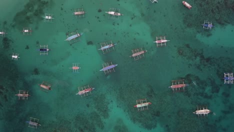 boracay, muchos barcos anclados en aguas cristalinas turquesas, corales visibles. desciende lentamente desde el aire.