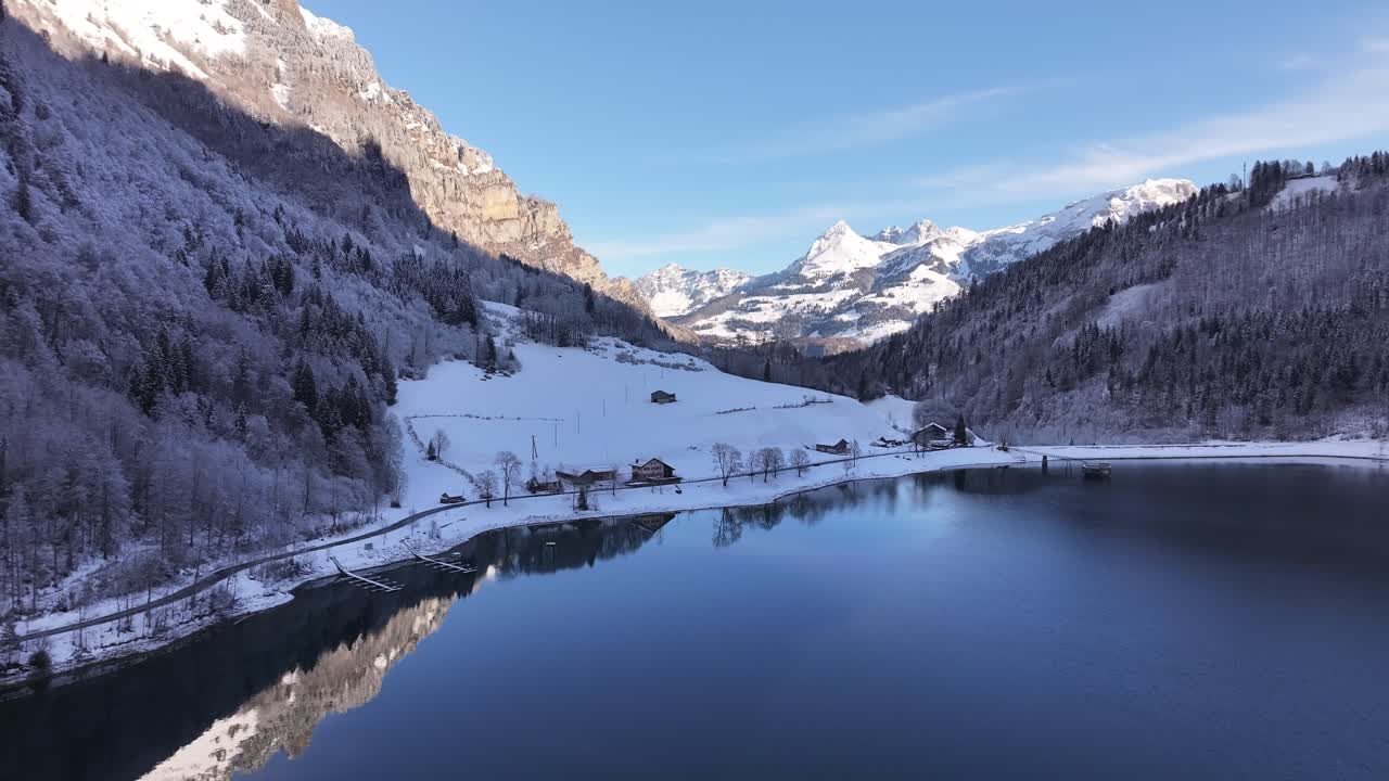 Winter wonderland. View of Lake Klöntalersee in Klöntal, Switzerland. Snow-capped mountains tower over the frozen lake, creating a magical winter wonderland.