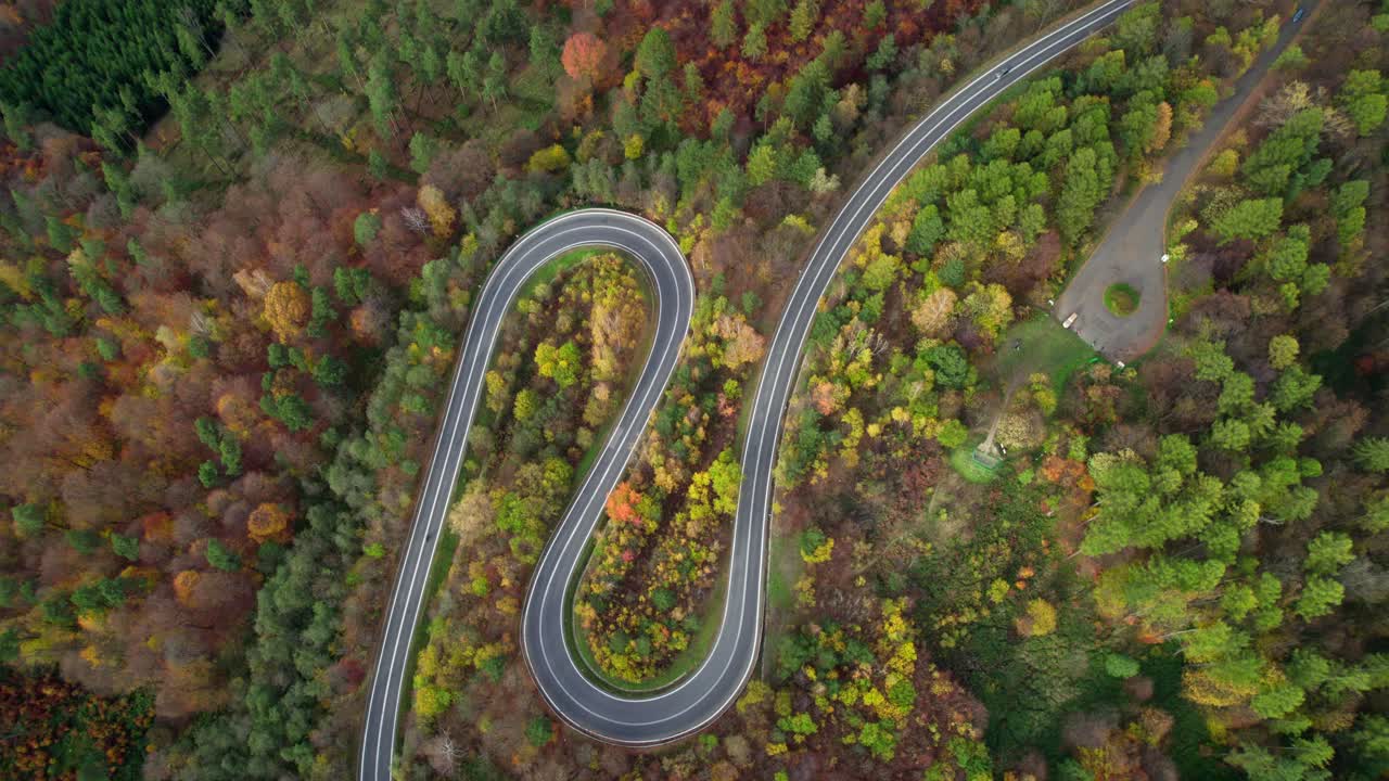 coche y moto conduciendo por una maravillosa carretera con curvas en las montañas rodeadas por un hermoso bosque otoñal en la naturaleza