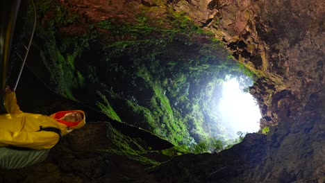 Vertical-shot-of-a-young-man-admiring-Algar-do-Carvao-volcanic-cone