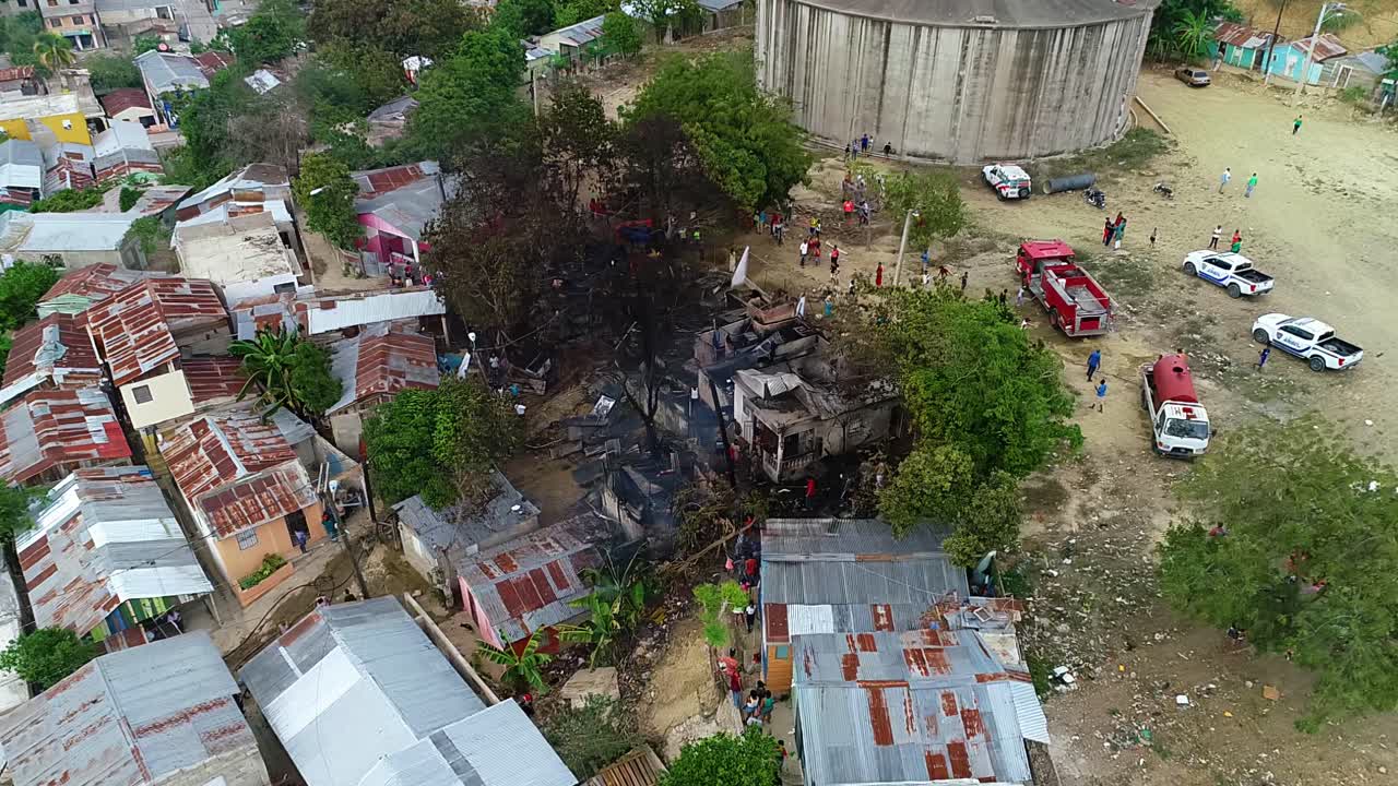 vista aérea alrededor de los bomberos y la gente en un edificio quemado, en los barrios bajos de la ciudad de méxico, américa central - órbita, disparo de drones
