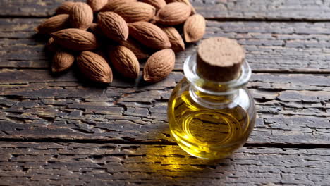 almond oil and almonds on wooden table