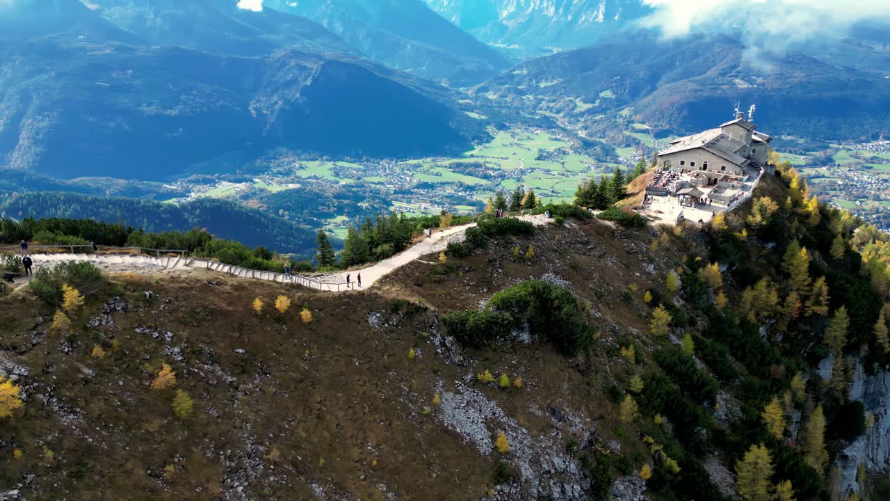 el pico de la montaña se eleva por encima del cielo despejado, proyectando una sombra dramática en el valle exuberante de abajo.